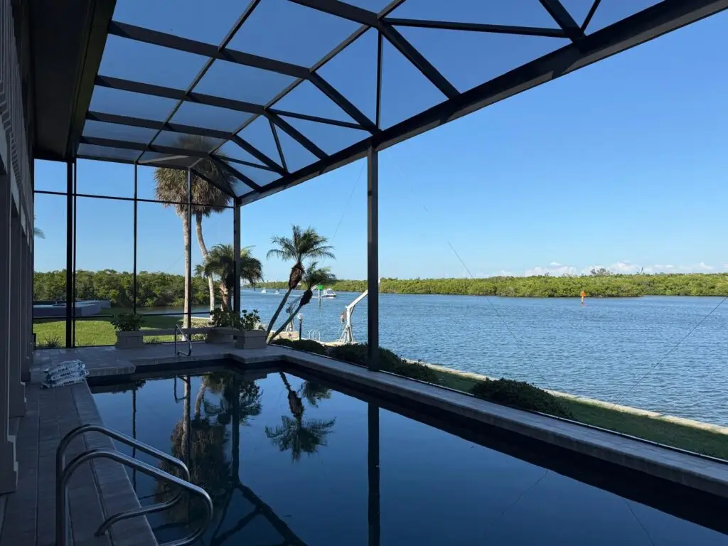 Screen enclosure overlooking pool and lake with open panoramic view
