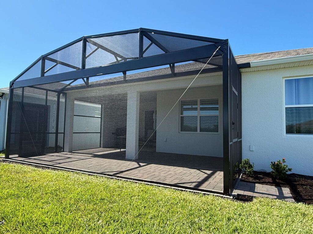 Large arched screen enclosure with paver floor installed on rear patio in Central Florida