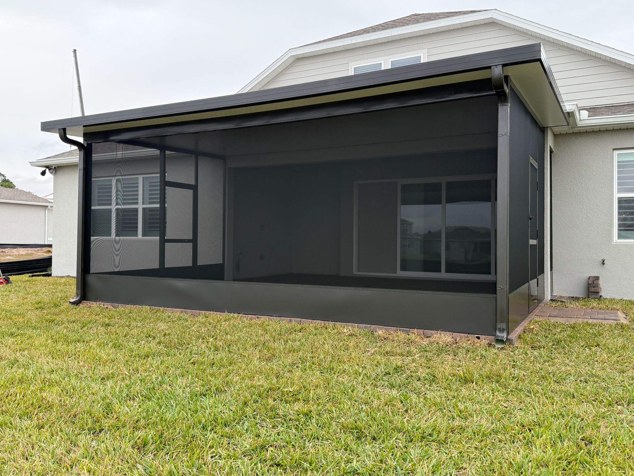 Insulated patio enclosure with solid roof panels at a residential home