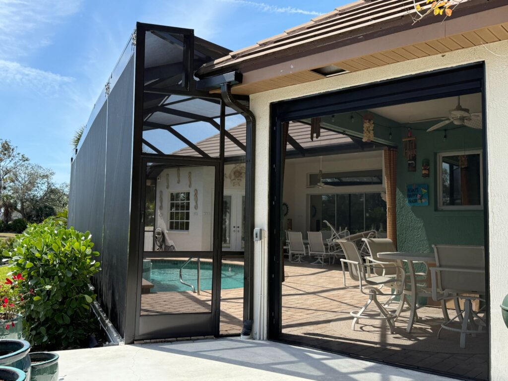 Screen enclosure entry with black aluminum frame and hinged door