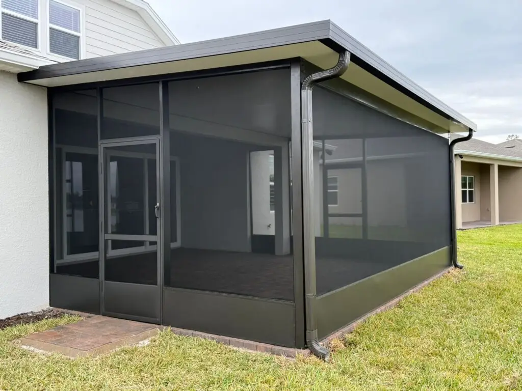 Screen enclosure side view with a panel roof, bronze aluminum frame and kickplate in Central Florida.